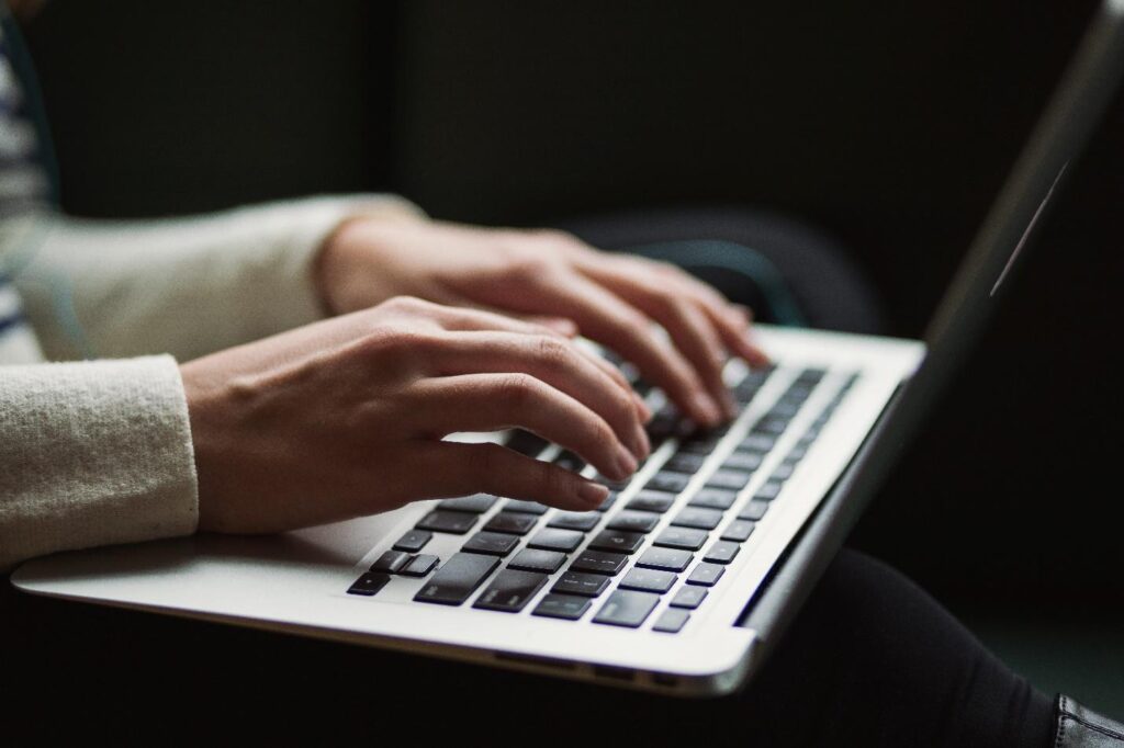 Mãos sobre o teclado de um notebook